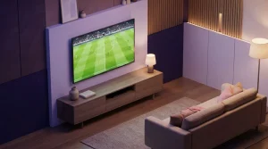 Fernsehgerät auf einem niedrigen Tisch vor einem Sofa mit beleuchtetem Spielfeld